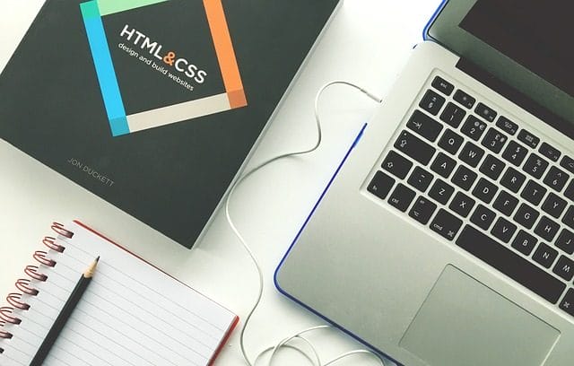 design and build website book next to laptop computer