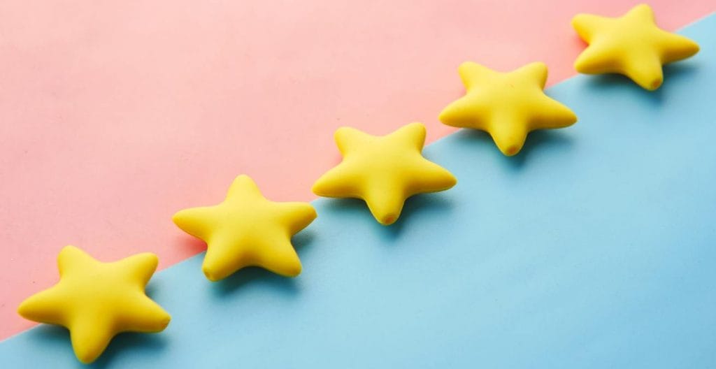 five yellow stars in icing on pink and blue background as proxy for landing page components social proof