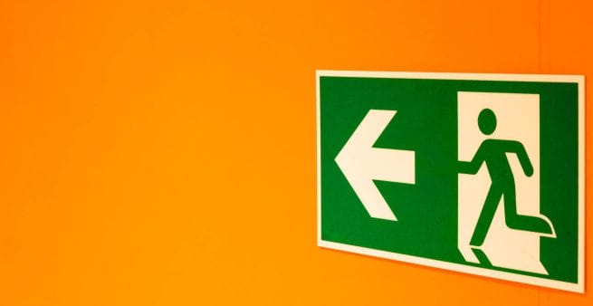 green exit sign on orange background representing traffic conversion as benefit of blogging for business